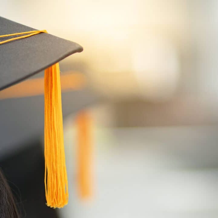 Young happy Asian woman university graduate in graduation gown and cap in the college campus. Education stock photo